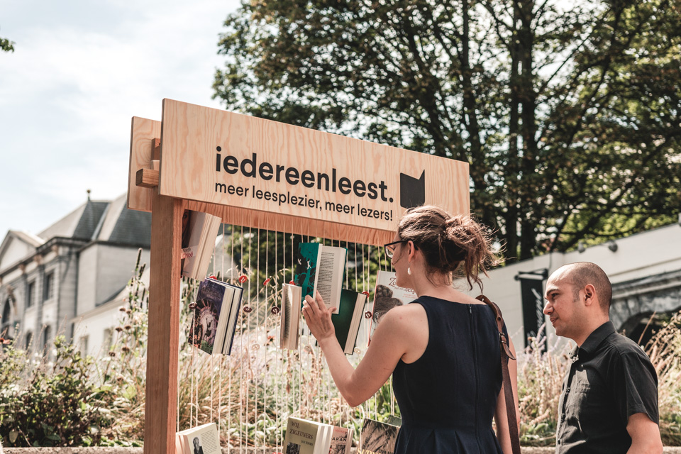 vrouw en man bekijken boeken in een boekenhangrek