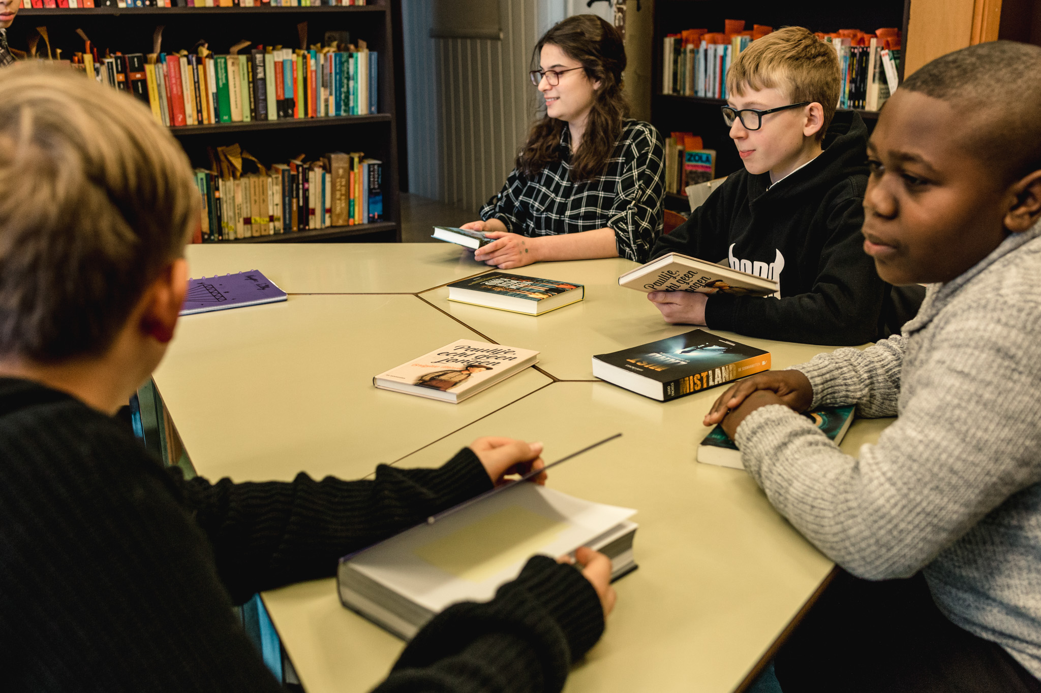 Leerlingen praten over boeken in de schoolbibliotheek