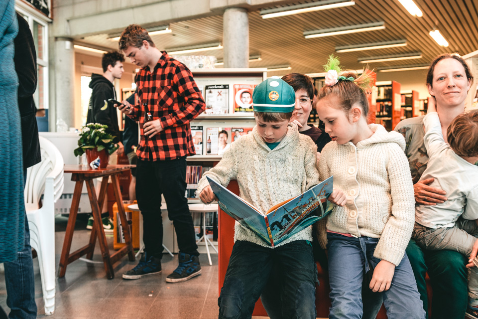 kinderen lezen samen in een prentenboek in de bibliotheek