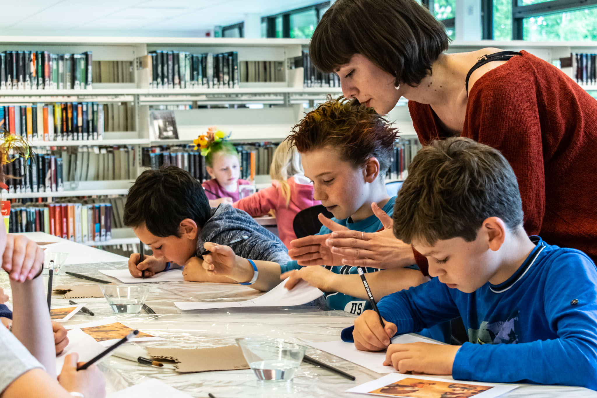 illustrator sassafras de bruyn geeft tips aan kinderen tijdens een tekenworkshop