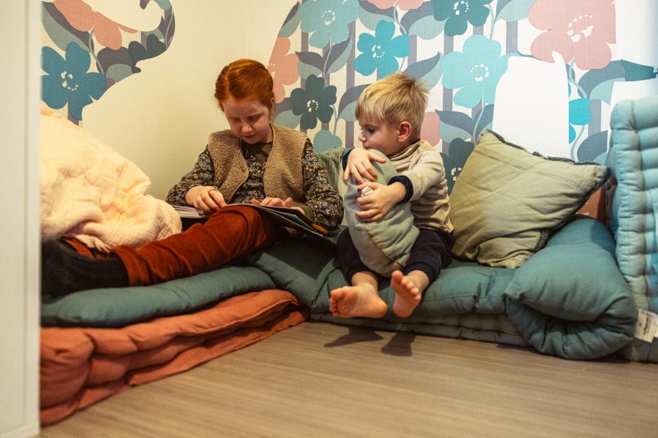 Merel en Sander zitten samen op kussens.