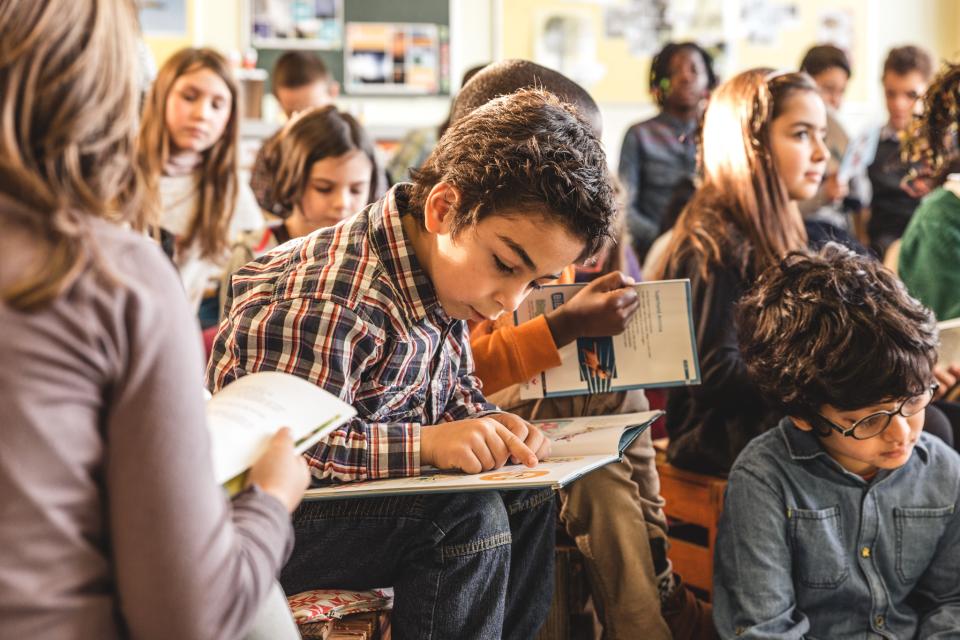 Lezende jongen in de klas