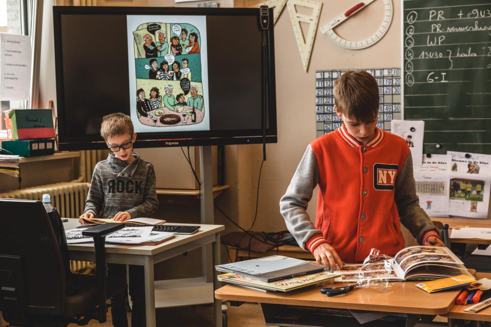 Leerlingen snuisteren in boeken in de klas