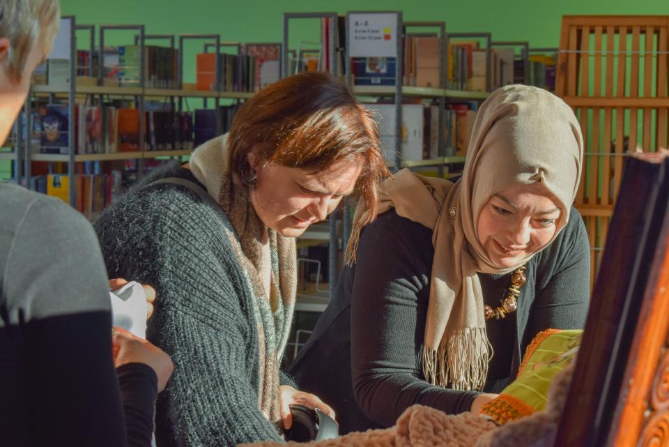 bezoekers bekijken een tentoonstelling in de bibliotheek