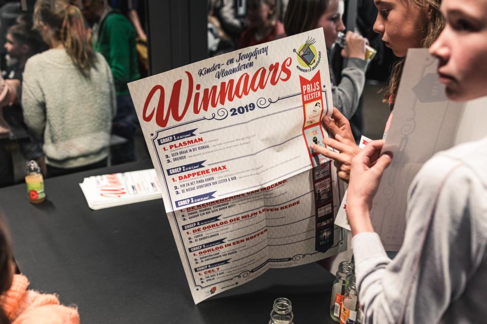 juryleden houden de affiche met de winnaars van de kinder- en jeugdjury vast